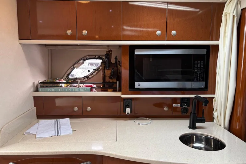 Slide: The Image of 2008 Sea Ray Sundancer 310 galley with microwave, sink, and wooden cabinetry. - 21