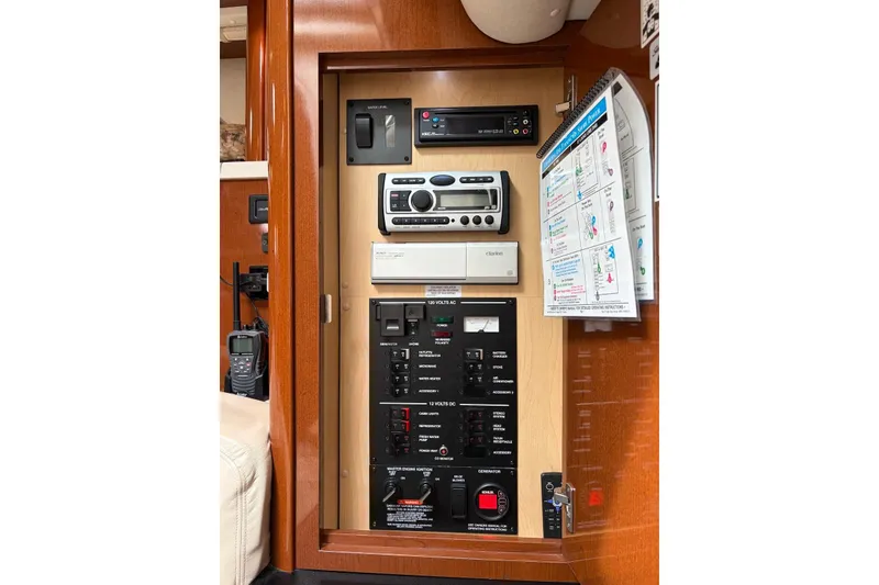 Slide: The Image of Control panel inside a 2008 Sea Ray Sundancer 310 boat, featuring various switches and a stereo system. - 23