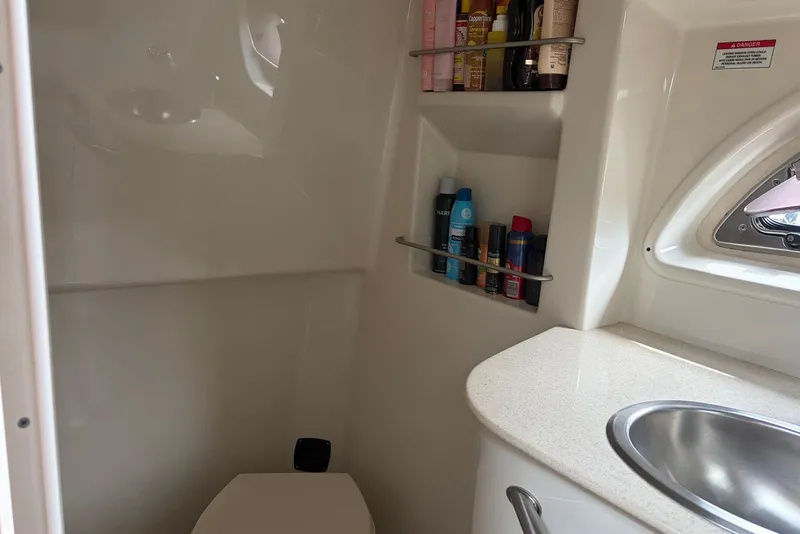 Slide: The Image of 2008 Sea Ray Sundancer 310 bathroom with sink, shelves, and toiletries. - 24