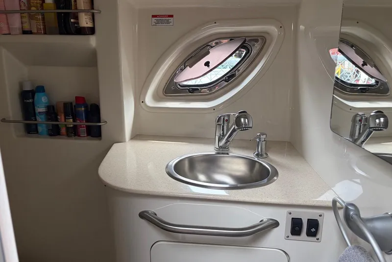 Slide: The Image of 2008 Sea Ray Sundancer 310 bathroom with sink, toiletries, and porthole window. - 25