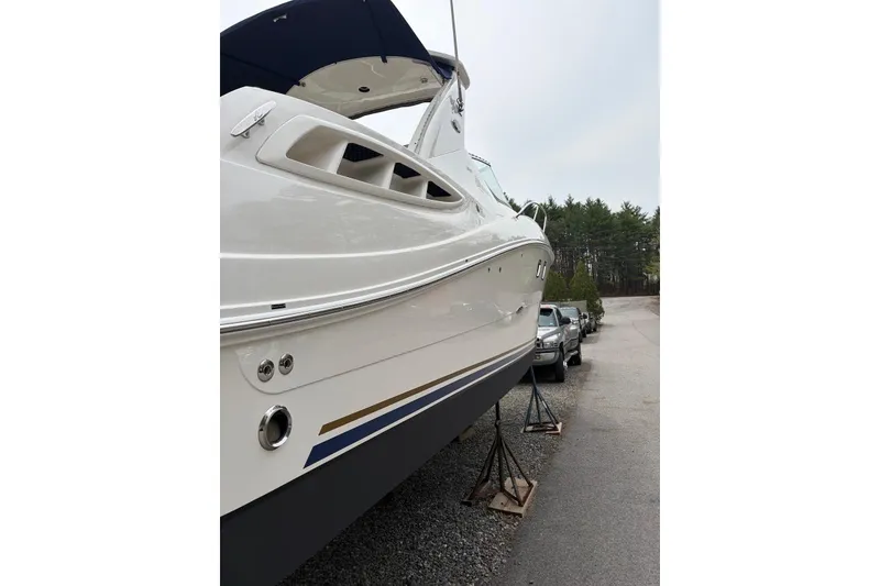 Slide: The Image of 2008 Sea Ray Sundancer 310 boat on stands, parked near vehicles. - 29