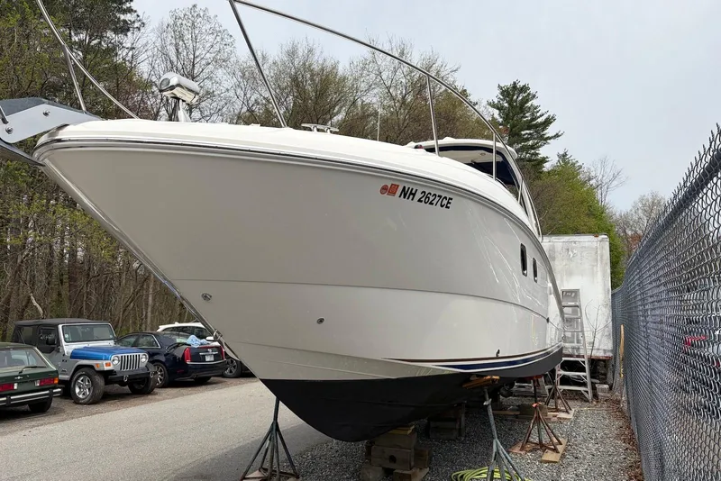 Slide: The Image of 2008 Sea Ray Sundancer 310 boat on stands, parked near vehicles and trees. - 31