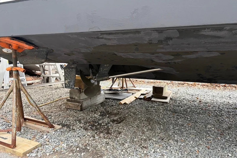 Slide: The Image of 2008 Sea Ray Sundancer 310 boat hull on stands, showing propeller and rudder. - 33