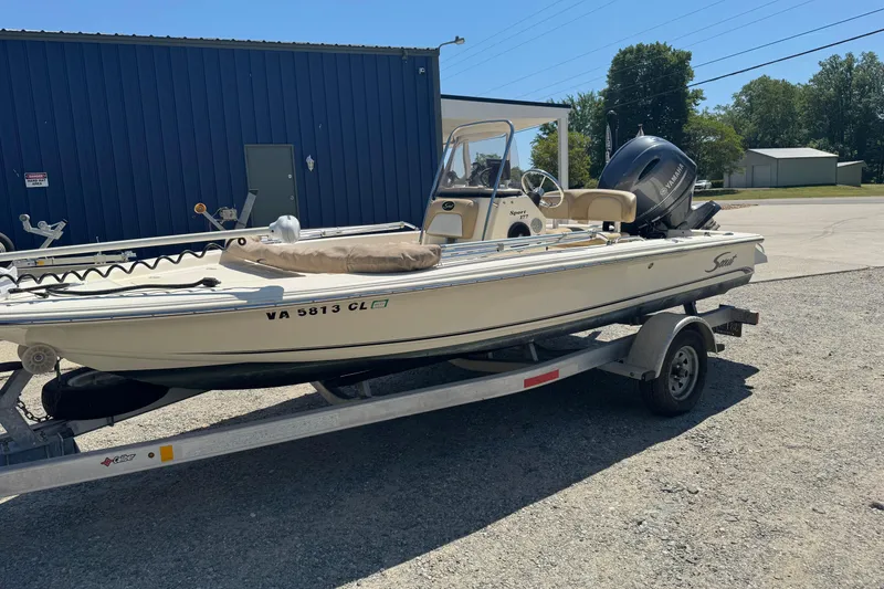 Slide: The Image of 2015 Scout 177 Sport boat on trailer, parked outdoors near a blue building. - 14