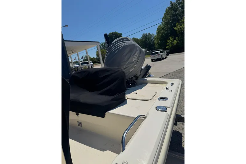 Slide: The Image of 2015 Scout 177 Sport boat with covered engine, parked outdoors. - 18