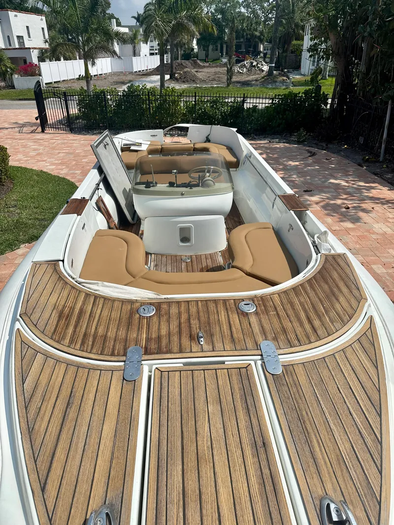 Slide: The Image of 2008 Castoldi Jet Tender 23 with teak decking and tan seating, docked on a brick driveway. - 2