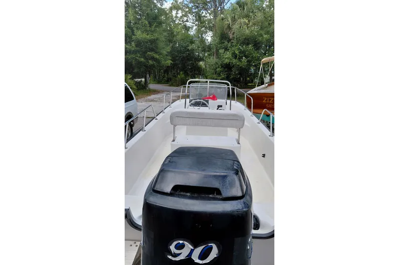 Slide: The Image of 2005 Boston Whaler 170 Montauk boat with 90 HP engine, parked outdoors. - 14