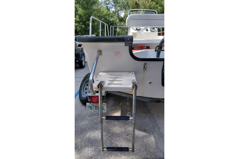 Slide: The Image of 2005 Boston Whaler 170 Montauk boat with rear ladder and trailer in parking area. - 16