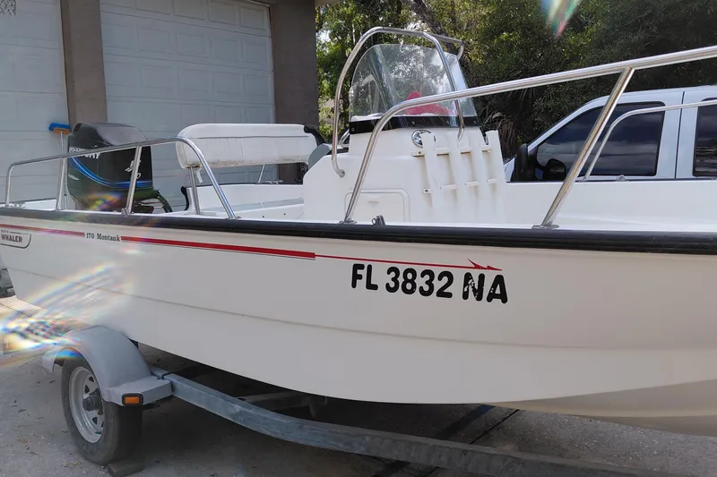 Slide: The Image of 2005 Boston Whaler 170 Montauk boat on trailer, parked near garage. - 2