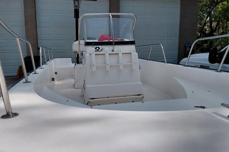 Slide: The Image of 2005 Boston Whaler 170 Montauk boat with center console, parked in front of garage. - 7
