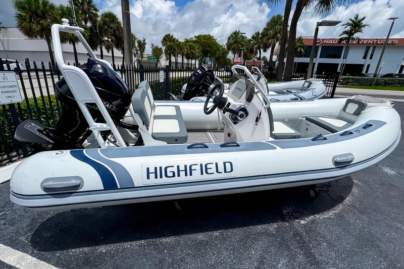 The Image of 2023 Highfield Classic 420 inflatable boat with outboard motor, parked outdoors. - 0