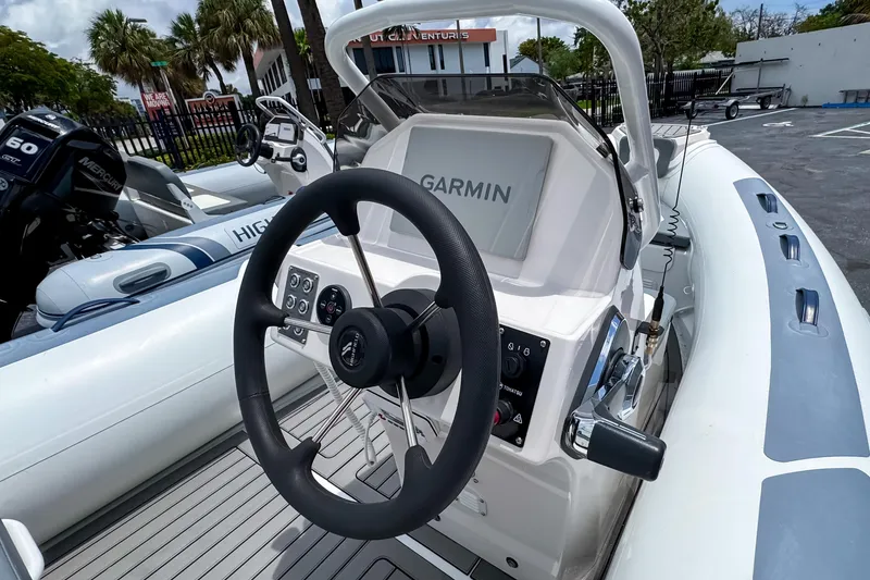 Slide: The Image of 2023 Highfield Classic 420 boat dashboard with Garmin navigation system and steering wheel. - 7