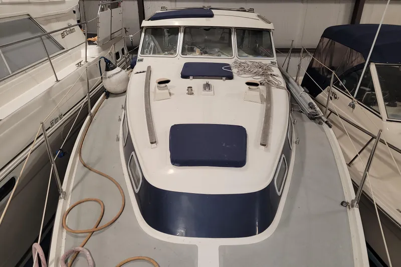 Slide: The Image of 1986 LM 32 boat in storage, featuring a white and blue deck with nautical equipment. - 10