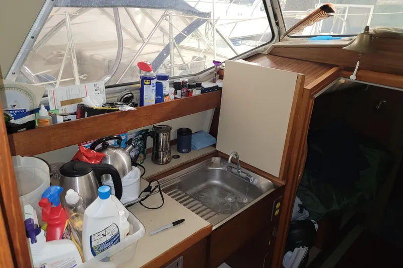 Slide: The Image of Interior of 1986 LM 32 boat with kitchen sink and various supplies. - 17
