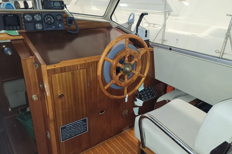 Slide: The Image of 1986 LM 32 boat cockpit with wooden steering wheel and navigation instruments. - 18