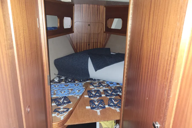 Slide: The Image of Cozy cabin interior of 1986 LM 32 boat with wooden finish and bedding. - 25