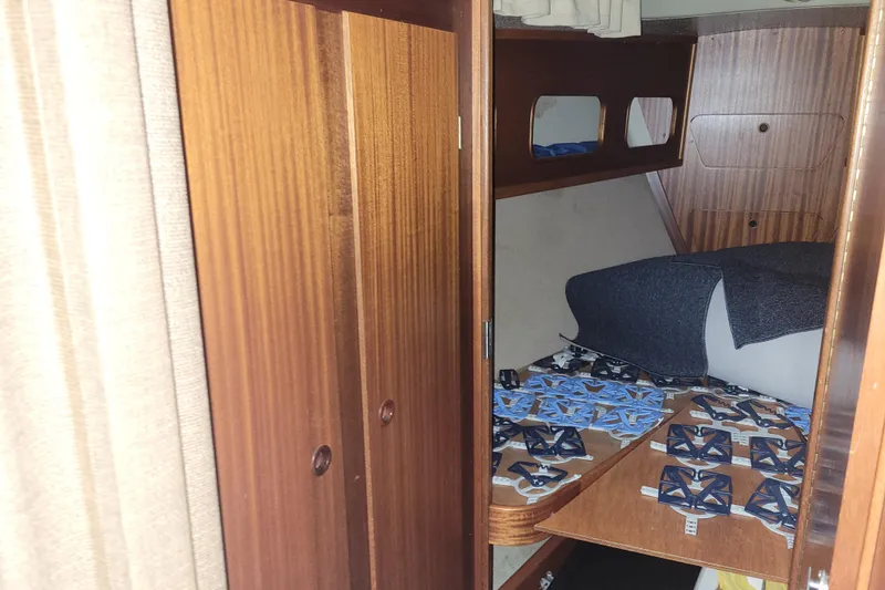 Slide: The Image of Interior cabin of a 1986 LM 32 boat with wooden paneling and bedding. - 26