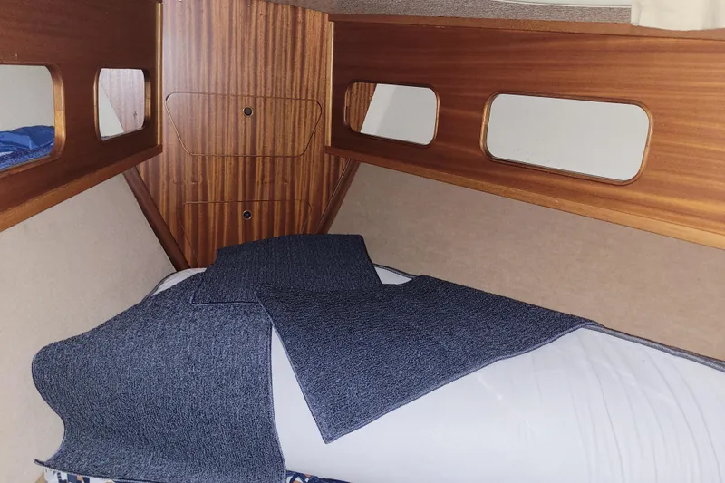 Slide: The Image of Cozy cabin interior of 1986 LM 32 boat with wooden paneling and bedding. - 28
