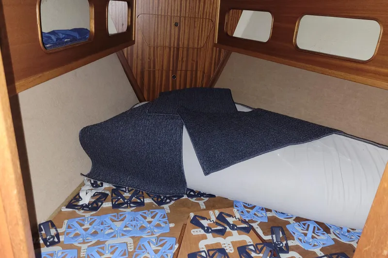 Slide: The Image of Interior cabin of a 1986 LM 32 boat with bedding and wooden paneling. - 29