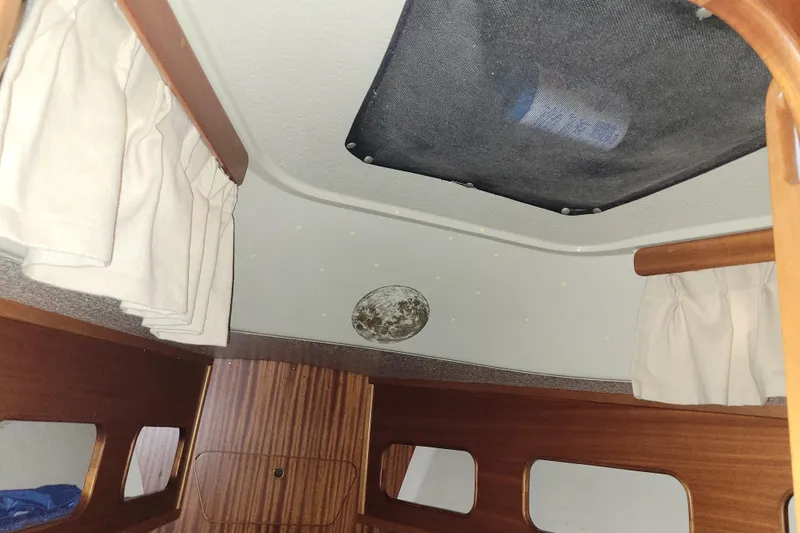 Slide: The Image of Interior cabin of a 1986 LM 32 boat with wood paneling and curtains. - 30