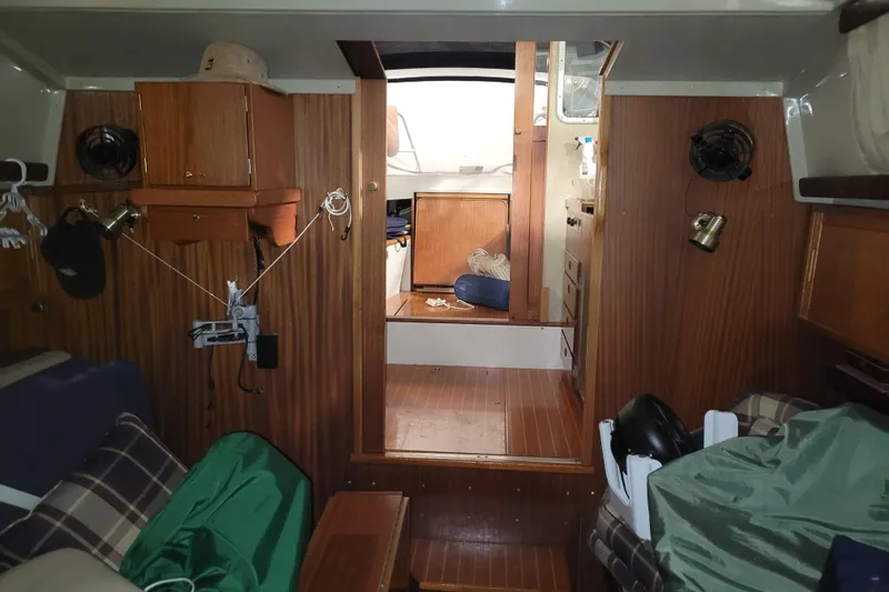 Slide: The Image of Interior of a 1986 LM 32 boat, featuring wood paneling and cozy cabin space. - 31