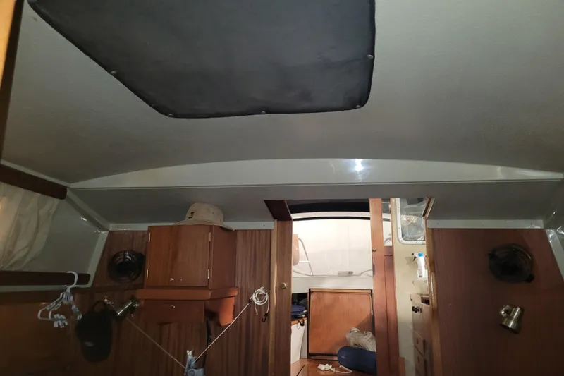 Slide: The Image of Interior of a 1986 LM 32 boat with wooden cabinets and ceiling hatch. - 32