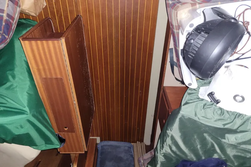 Slide: The Image of Interior of 1986 LM 32 boat with wooden paneling and stored equipment. - 33
