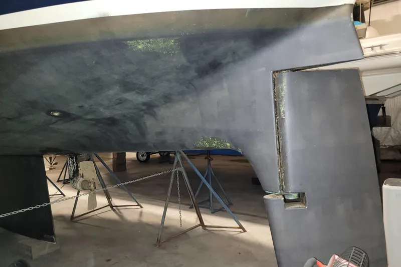 Slide: The Image of 1986 LM 32 boat hull and rudder in dry dock, supported by stands. - 35