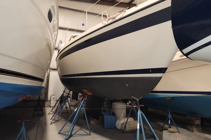 Slide: The Image of 1986 LM 32 sailboat in storage, supported by stands in a warehouse. - 40