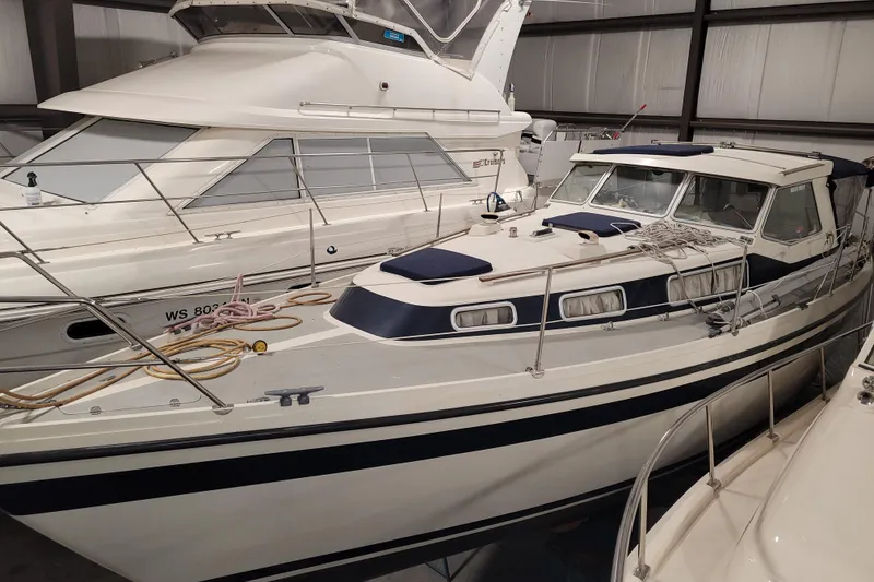 Slide: The Image of 1986 LM 32 boat in storage, featuring a sleek design and white exterior. - 6