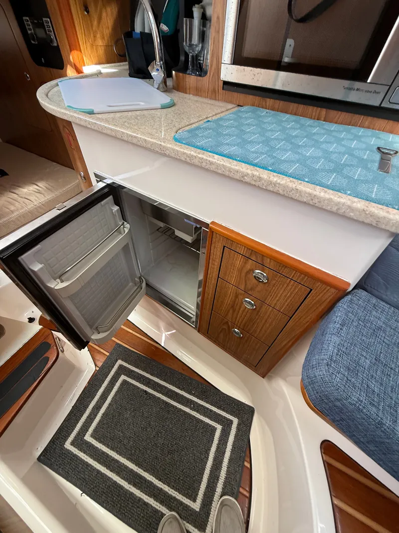 Slide: The Image of Interior of a 2011 Pursuit 315 OS with open fridge door. - 6