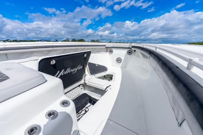 Slide: The Image of 2019 Yellowfin 42 Offshore boat interior with seating and storage, under a vibrant blue sky. - 28