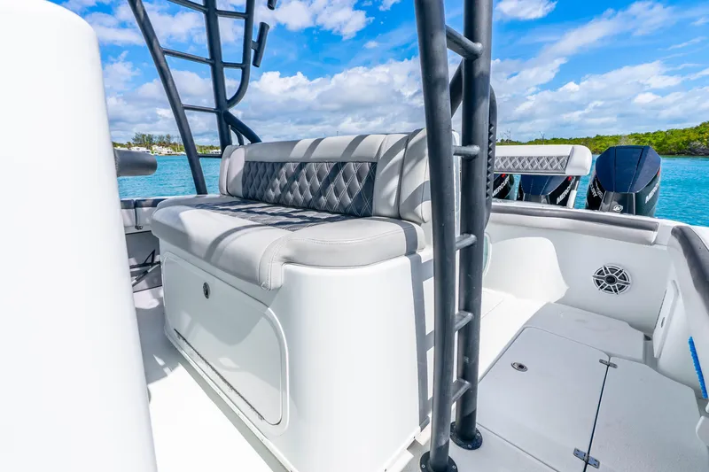 Slide: The Image of 2019 Yellowfin 42 Offshore boat interior with cushioned seating and ocean backdrop. - 35