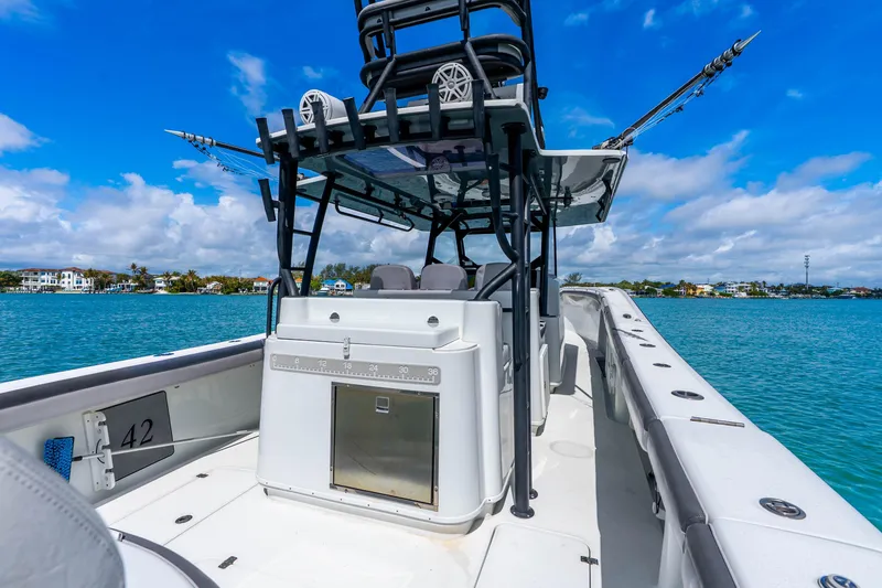 Slide: The Image of 2019 Yellowfin 42 Offshore boat on clear blue water, showcasing spacious deck and fishing equipment. - 47
