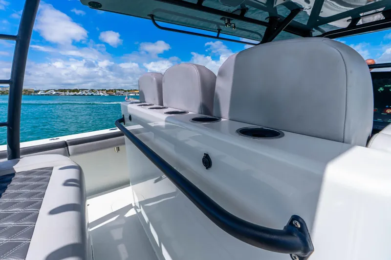 Slide: The Image of 2019 Yellowfin 42 Offshore boat interior with seating, cup holders, and ocean view. - 50