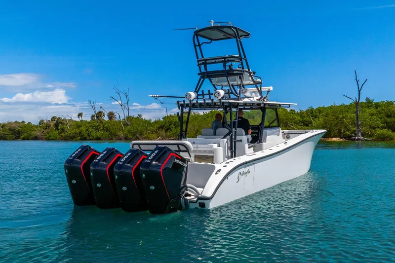 Slide: The Image of 2019 Yellowfin 42 Offshore boat with four outboard engines on a serene waterway. - 9
