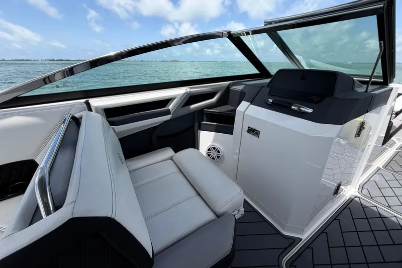 Slide: The Image of 2022 Cobalt R8 Outboard boat interior with sleek seating and modern dashboard on open water. - 13
