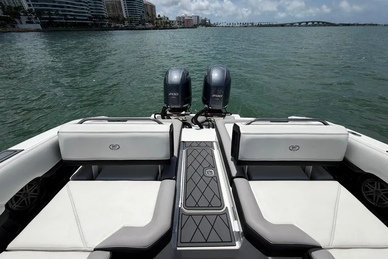 Slide: The Image of 2022 Cobalt R8 Outboard boat with dual engines, luxurious seating, and scenic waterfront view. - 15