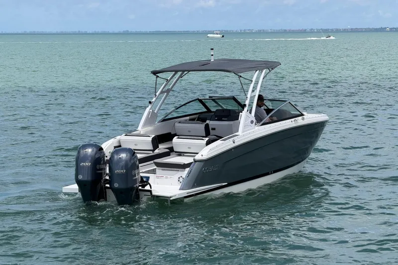 Slide: The Image of 2022 Cobalt R8 Outboard boat cruising on open water with dual engines. - 5