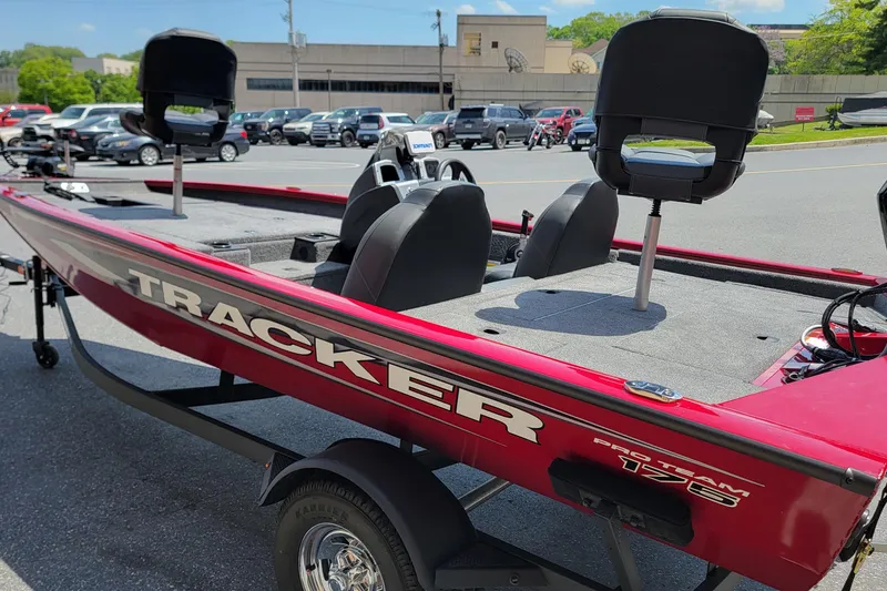 Slide: The Image of 2025 Tracker Pro Team 175 boat in parking lot, featuring red exterior and elevated seats. - 5