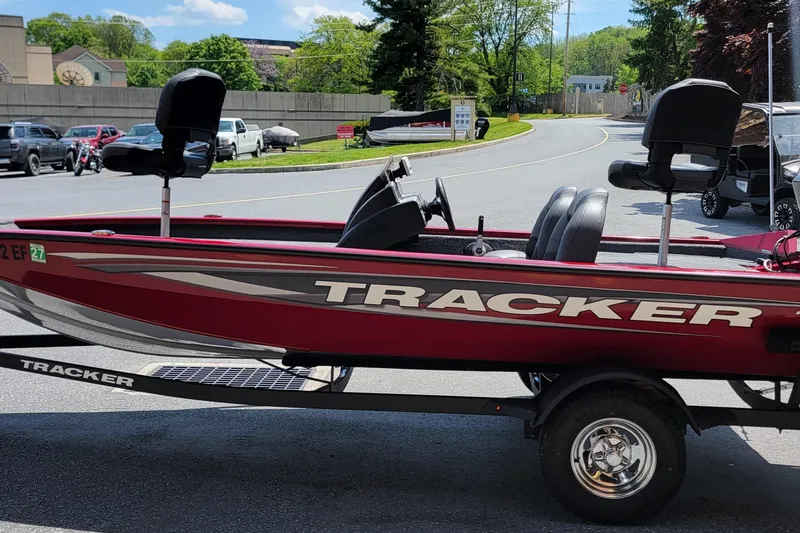 Slide: The Image of Red 2025 Tracker Pro Team 175 boat on trailer, parked in a lot. - 9