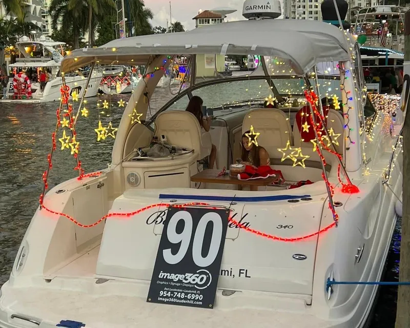 Slide: The Image of 2006 Sea Ray 340 Sundancer decorated with star lights at a festive marina event. - 26