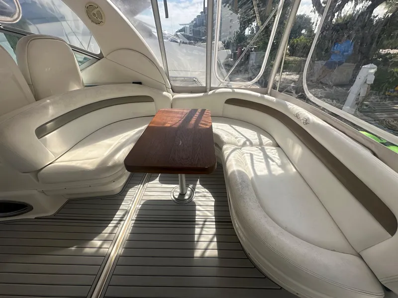 Slide: The Image of Interior of 2006 Sea Ray 340 Sundancer with white seating and wooden table. - 44