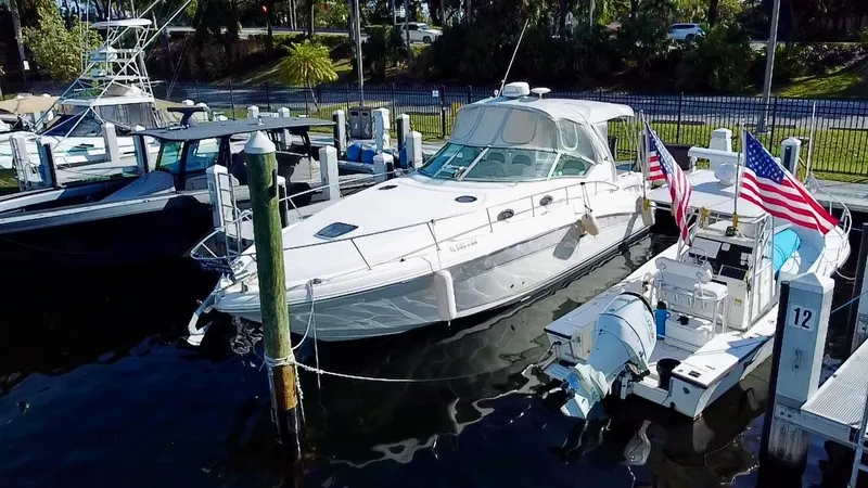 Slide: The Image of 2006 Sea Ray 340 Sundancer docked with American flags, surrounded by other boats. - 8