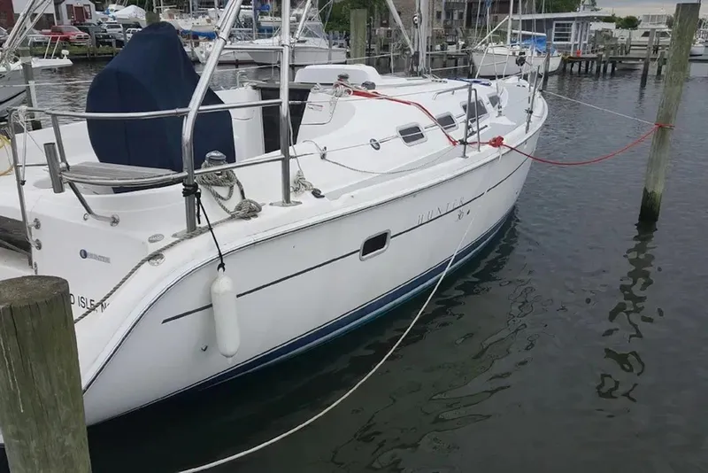 The Image of 2006 Hunter 36 sailboat docked at a marina, featuring sleek white design. - 0