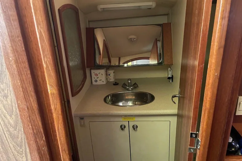 Slide: The Image of Compact bathroom in a 2006 Hunter 36 sailboat, featuring a sink and mirror. - 11