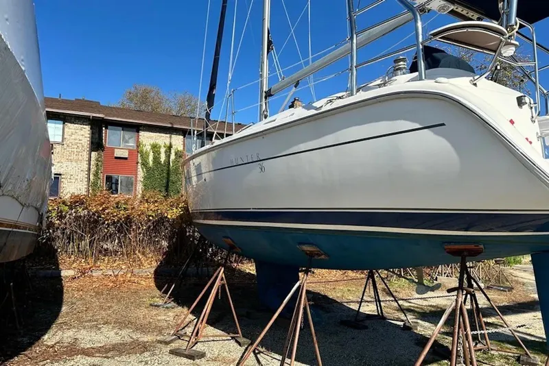 Slide: The Image of 2006 Hunter 36 sailboat on stands, outdoor storage, clear blue sky. - 13