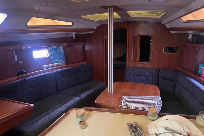 Slide: The Image of Interior of a 2006 Hunter 36 sailboat with cozy seating and wooden finishes. - 4