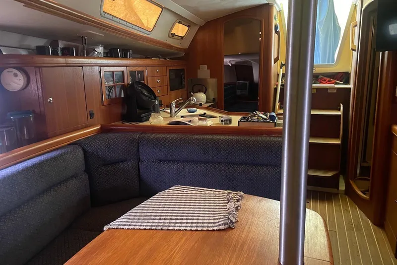 Slide: The Image of Interior of a 2006 Hunter 36 sailboat with cozy seating and wooden cabinetry. - 6