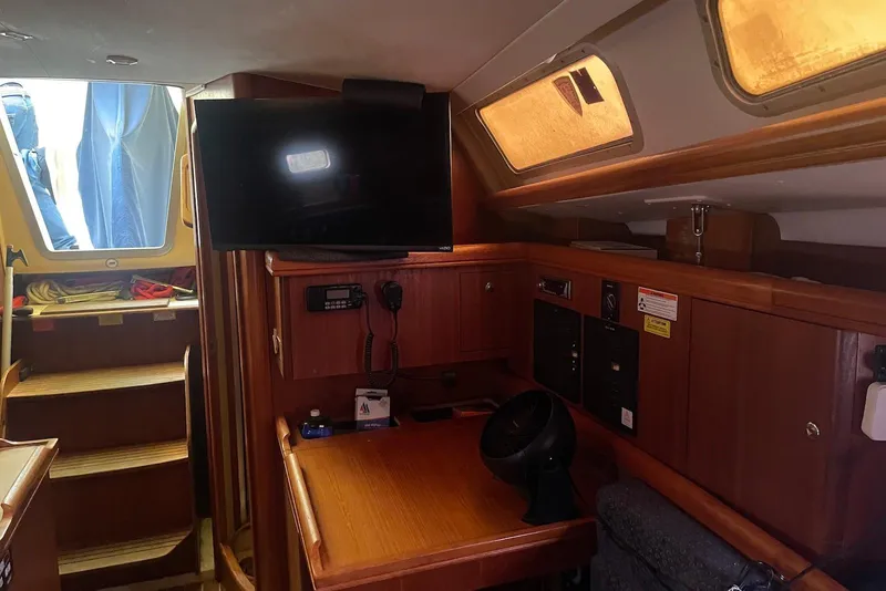Slide: The Image of Interior of a 2006 Hunter 36 sailboat with wooden cabinetry and mounted TV. - 7